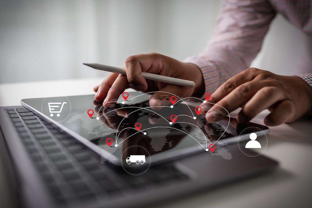 Hand interacting with a digital logistics map on a tablet, highlighting the global connectivity managed by Del Bravo