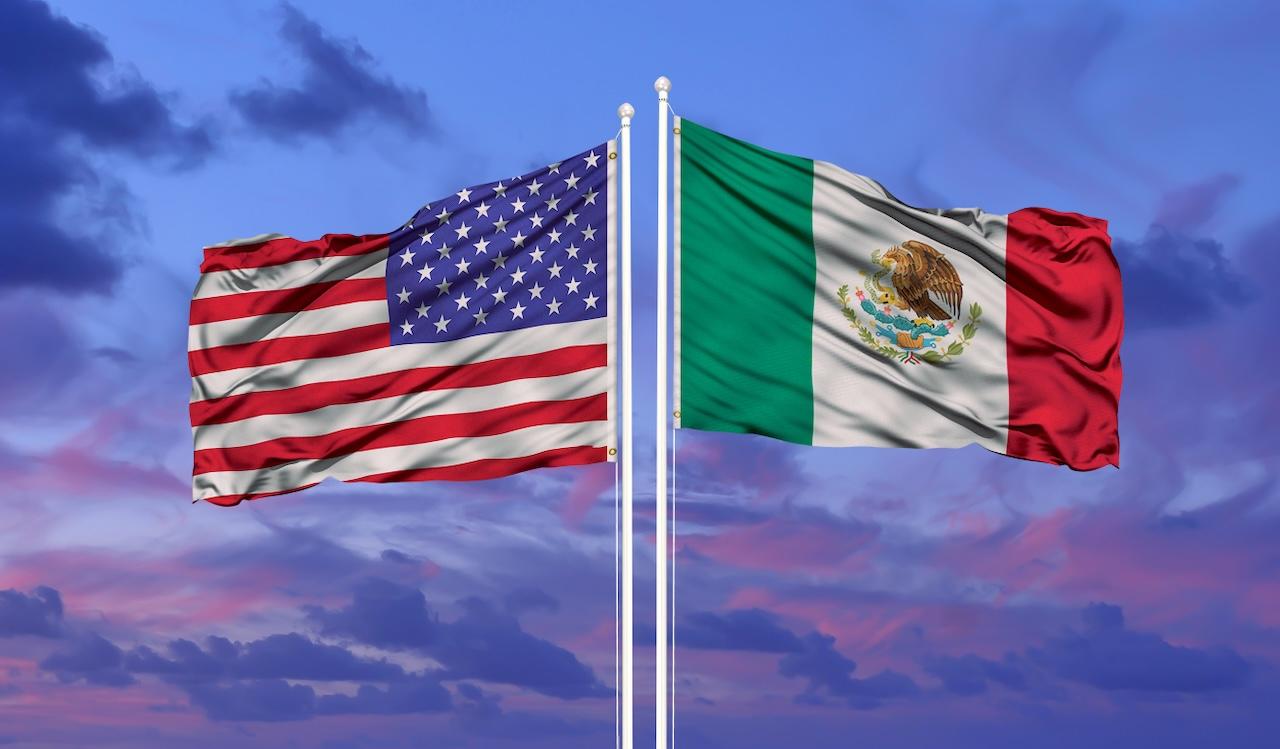 Banderas de Estados Unidos y México ondeando juntas, simbolizando la experiencia de Del Bravo en la gestión de operaciones transfronterizas entre ambos países