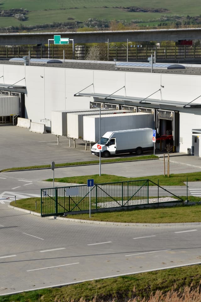 Camión de carga en la entrada de una instalación industrial, destacando la logística de transporte eficiente gestionada por Del Bravo