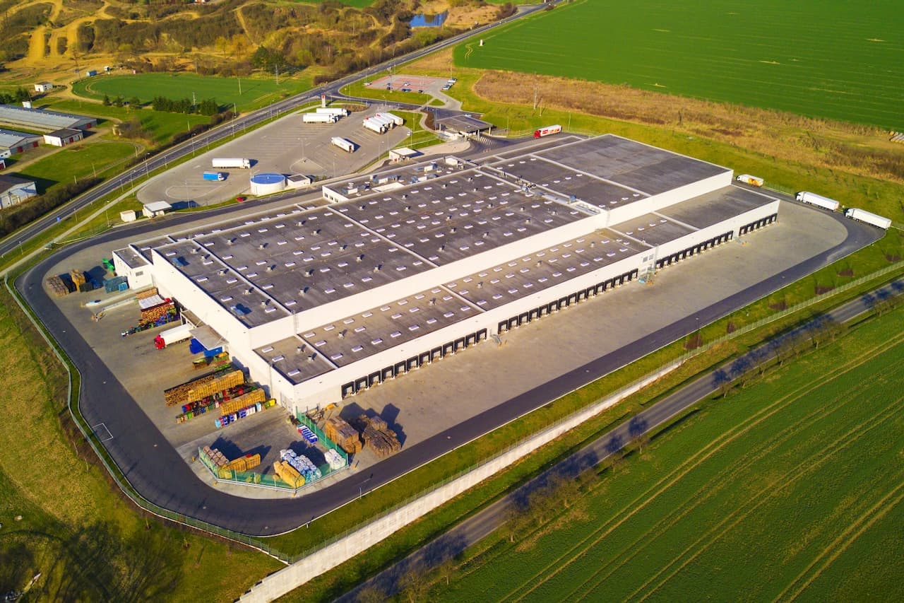 Aerial view of a large industrial facility in a rural setting, illustrating Del Bravo's advanced infrastructure for large-scale logistics management