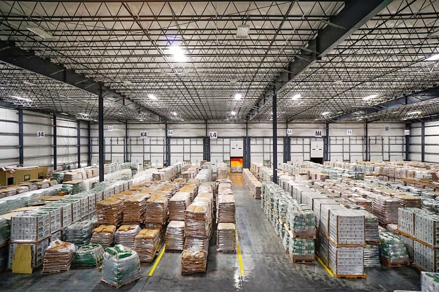 Interior of a spacious warehouse with products organized on pallets, showcasing Del Bravo's capacity to handle large volumes of inventory